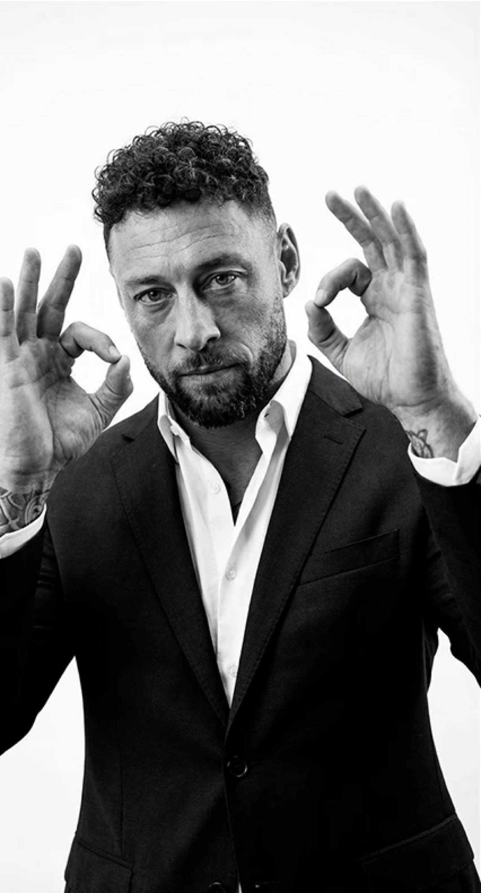 Troy Laing facing the camera, both hands raised in an OK gesture